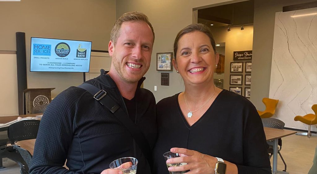 Man and woman with drinks posing in Cleary Co Design room